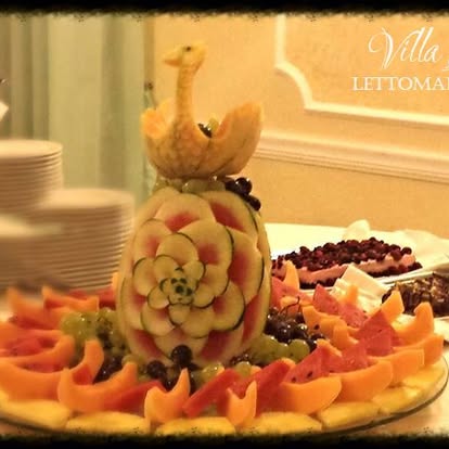 Composizione di frutta con un cigno intagliato nel melone e un'anguria decorata a fiori