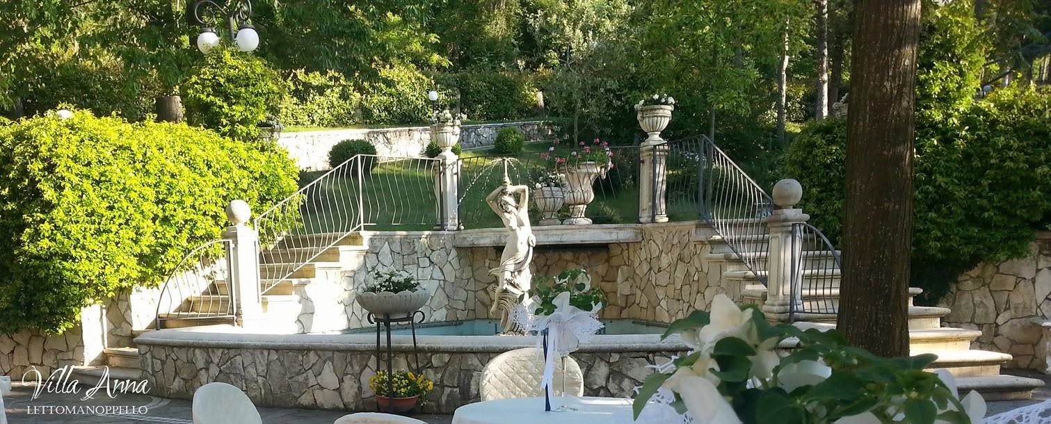 Fontana con statua ai piedi di una doppia scalinata in pietra nel giardino di Villa Anna